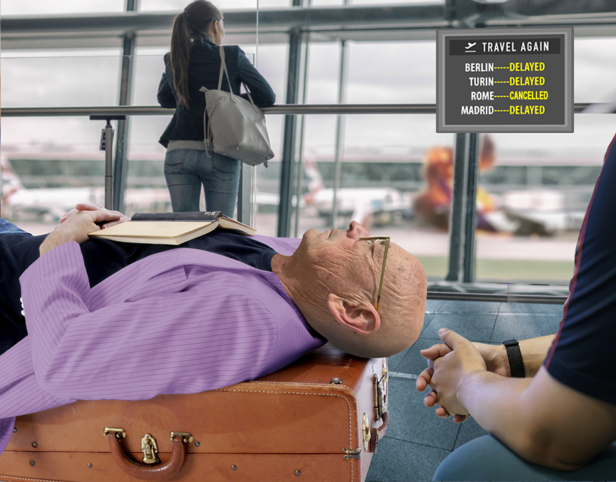photo of Russ Hatz sleeping on suitcase in flight boarding area
